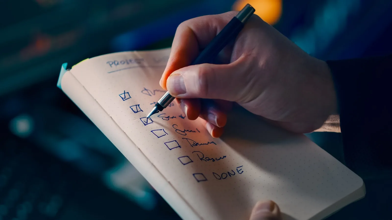 Eine Hand, die bei Lampenlicht Kästchen auf einer handschriftlichen Projekt-Checkliste abhakt, symbolisiert einen strukturierten Rahmen zur Bewertung von KI-Telefonassistenten-Anbietern